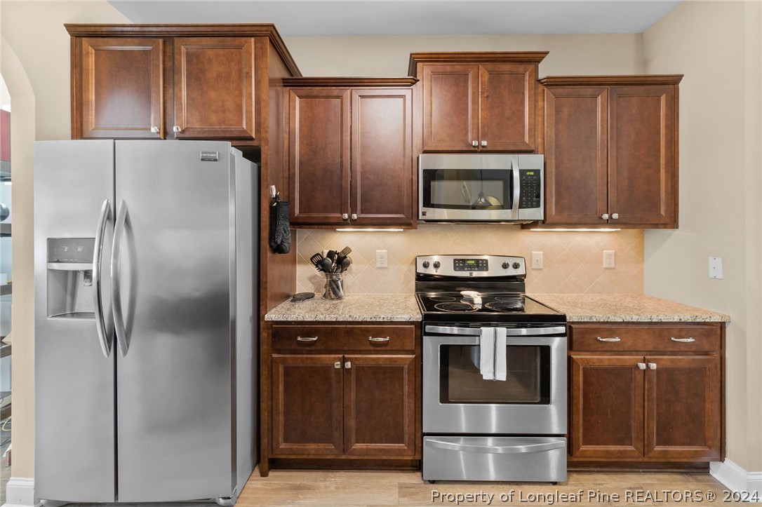 129 Warren Lake Road Aberdeen, NC 28315 - Photo 10 of 50 a kitchen with granite countertop a refrigerator stove and microwave