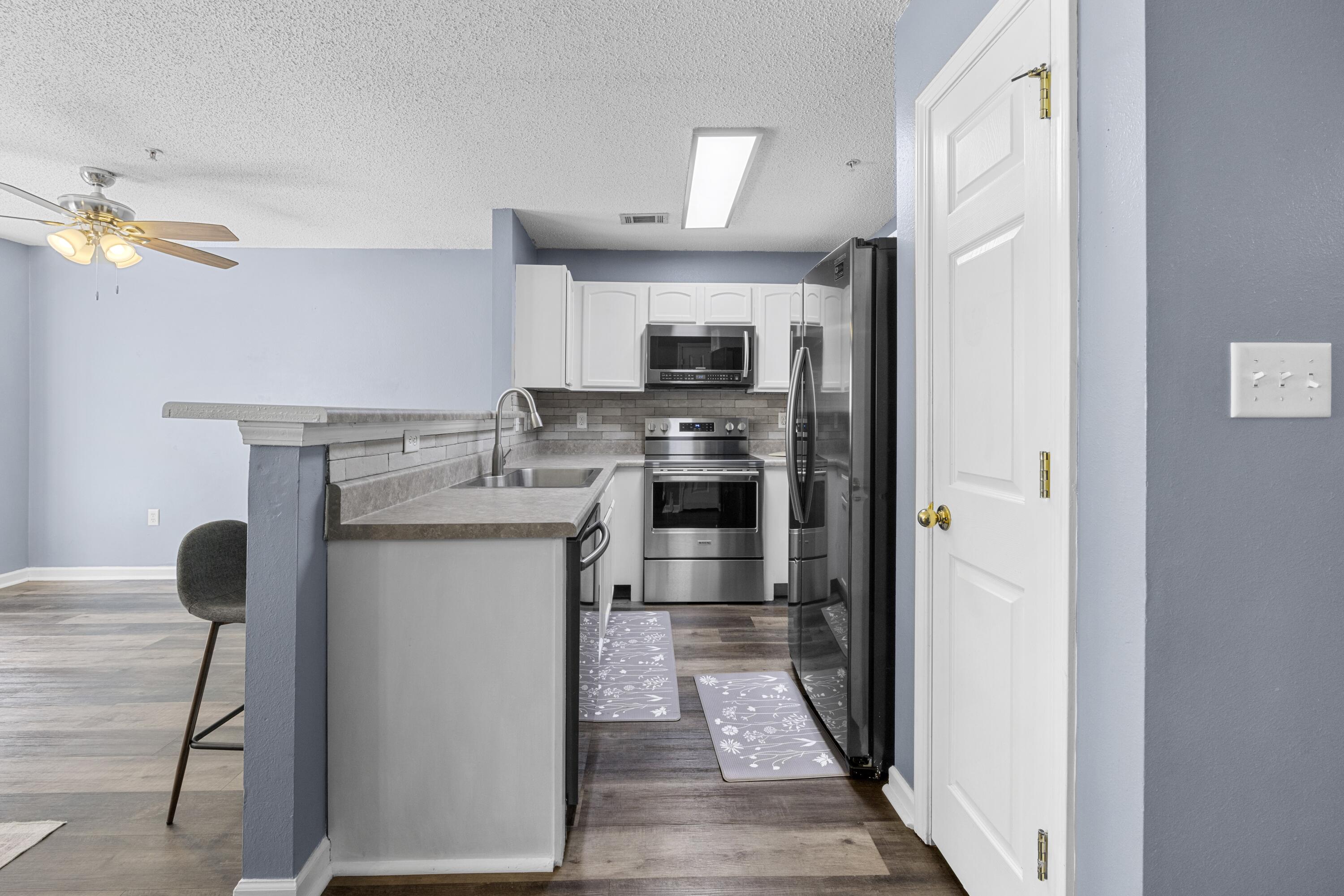 313 Crooked Pine Trail Crestview, FL 32539 - Photo 11 of 43 a kitchen with stainless steel appliances granite countertop a sink stove and refrigerator