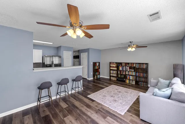 a living room with furniture and a wooden floor