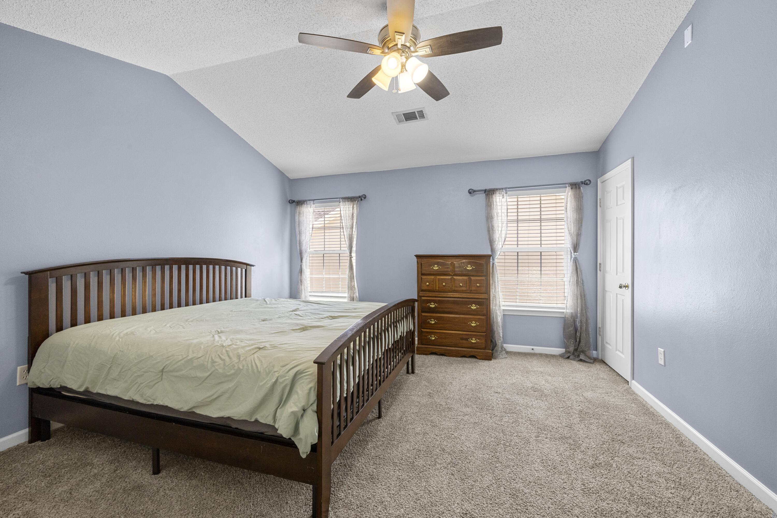 313 Crooked Pine Trail Crestview, FL 32539 - Photo 19 of 43 a bedroom with a bed and a chandelier