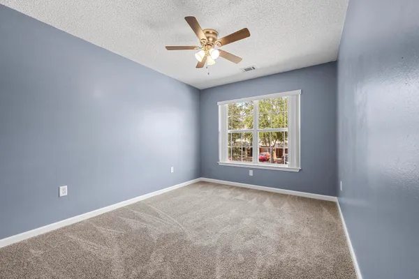 a view of an empty room with a ceiling fan