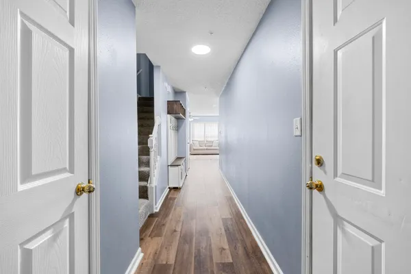 a view of a hallway with wooden floor and staircase
