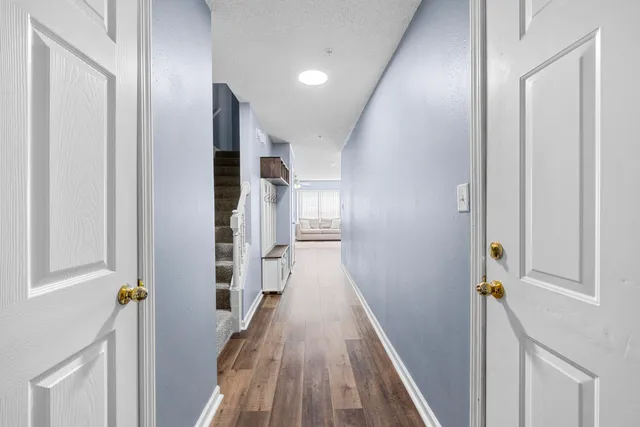 a view of a hallway with wooden floor and staircase