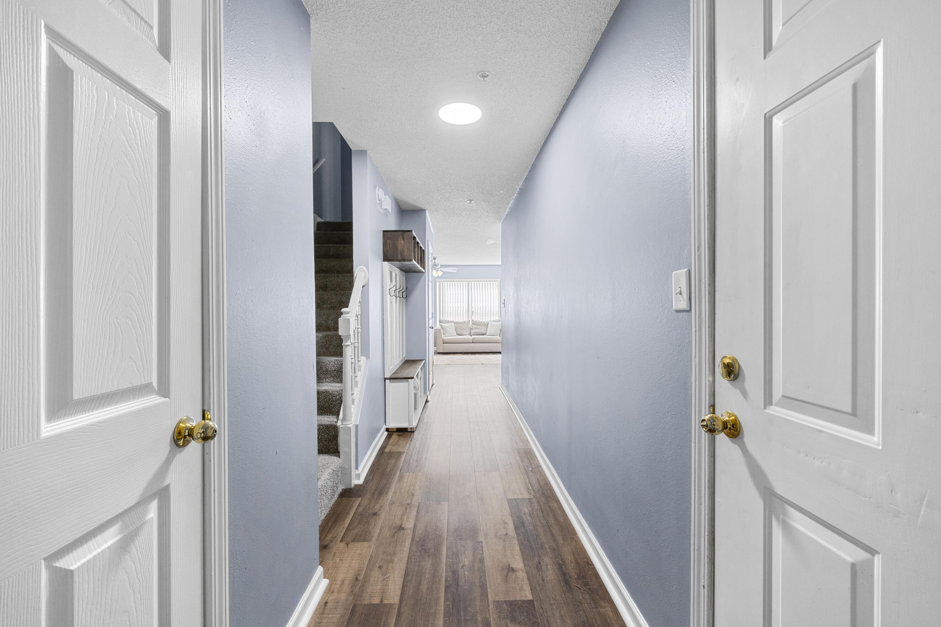 313 Crooked Pine Trail Crestview, FL 32539 - Photo 3 of 43 a view of a hallway with wooden floor and staircase