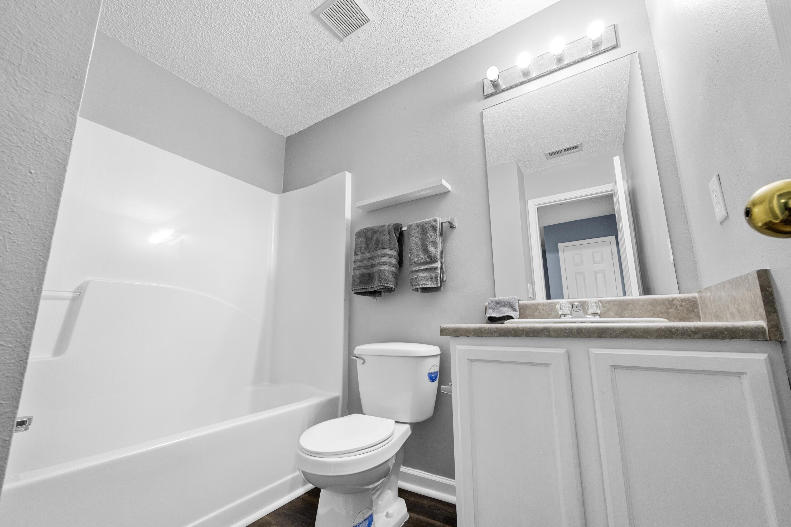 313 Crooked Pine Trail Crestview, FL 32539 - Photo 31 of 43 a bathroom with a granite countertop sink a toilet a mirror and shower