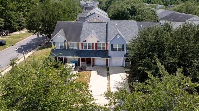 an aerial view of a house with swimming pool and large trees