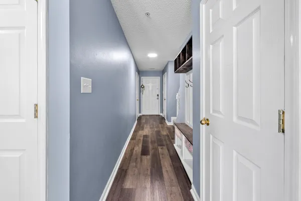 a view of a hallway with wooden floor and staircase