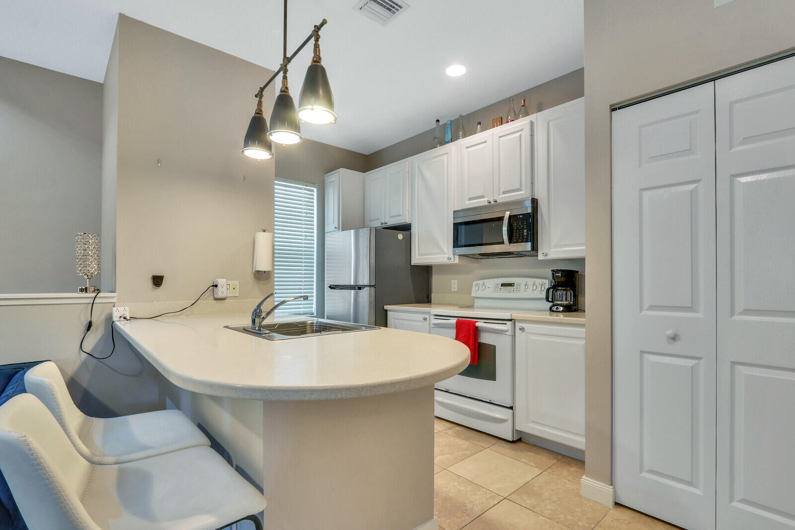 101 St Pierre Way Jupiter, FL 33458 - Photo 38 of 57 a kitchen with stainless steel appliances kitchen island granite countertop a sink and a refrigerator