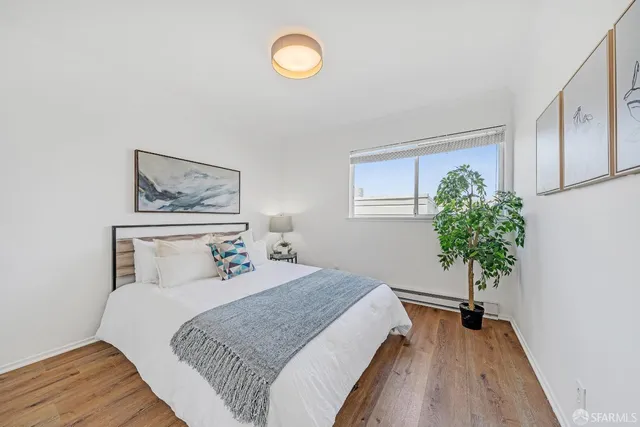 a bedroom with a bed and a potted plant