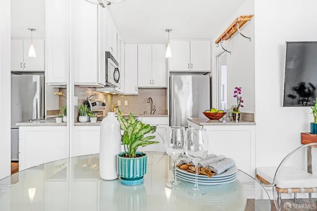 a kitchen with a refrigerator and potted plant