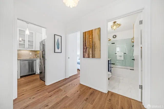 a view of a room with wooden floor and a bathroom