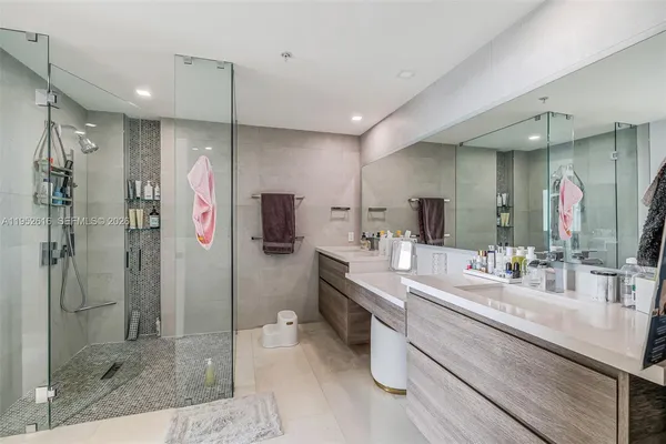 a bathroom with a double vanity sink mirror and shower