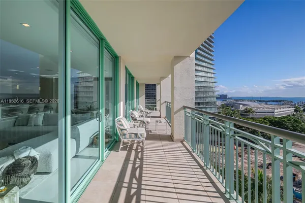 a balcony with wooden floor table and chairs