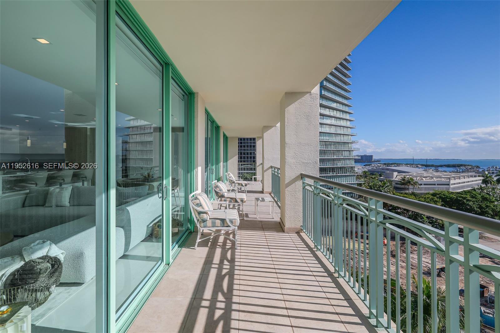 3400 Southwest 27th Avenue, Unit 802 Miami, FL 33133 - Photo 15 of 19 a balcony with wooden floor table and chairs