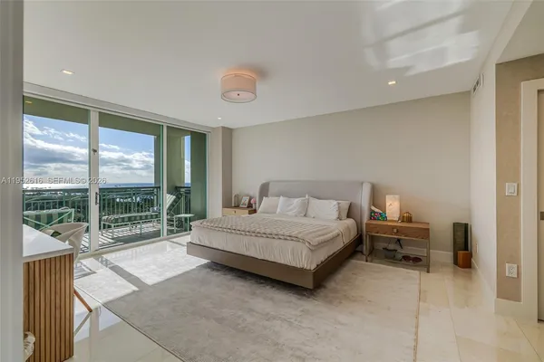 a spacious bedroom with a bed and a large window