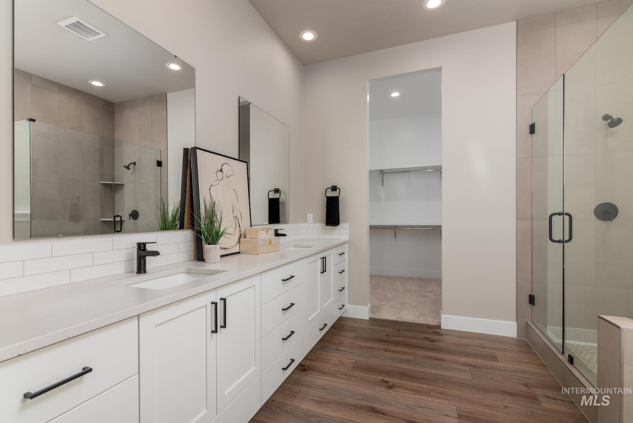 15249 Steel Cloud Avenue Caldwell, ID 83607 - Photo 23 of 46 Full bathroom with double vanity, a stall shower, a walk in closet, recessed lighting, and dark wood-style flooring