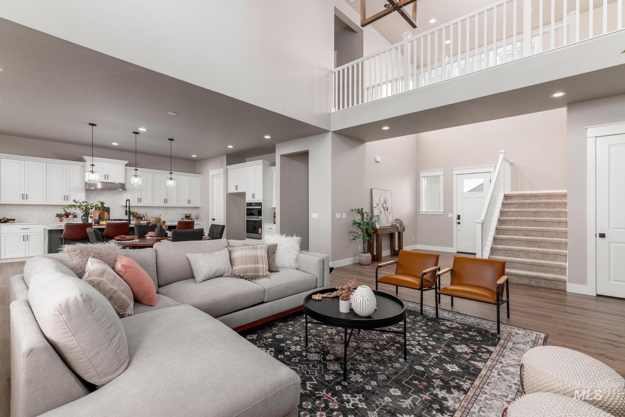 15249 Steel Cloud Avenue Caldwell, ID 83607 - Photo 5 of 46 Living room featuring stairway, recessed lighting, dark wood-type flooring, and a towering ceiling