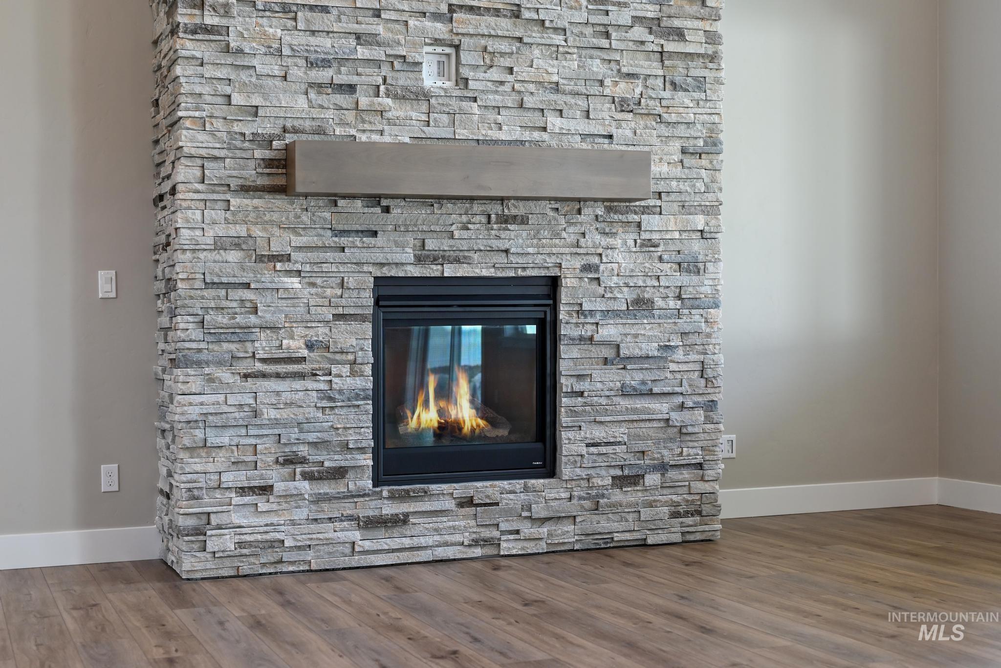 15249 Steel Cloud Avenue Caldwell, ID 83607 - Photo 8 of 46 Detailed view of a stone fireplace and wood finished floors