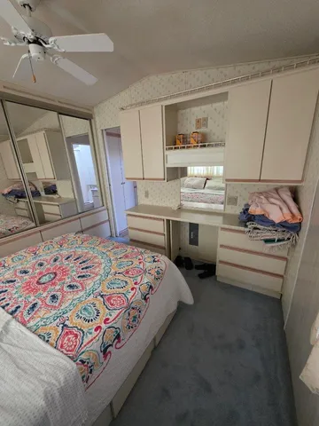 a bedroom with a bed and a mirror on the dresser