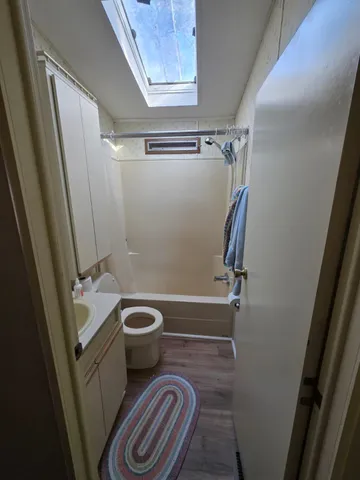 a bathroom with a sink a toilet a tub and shower