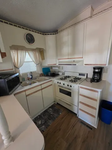 a kitchen with a stove a sink and a wooden cabinets