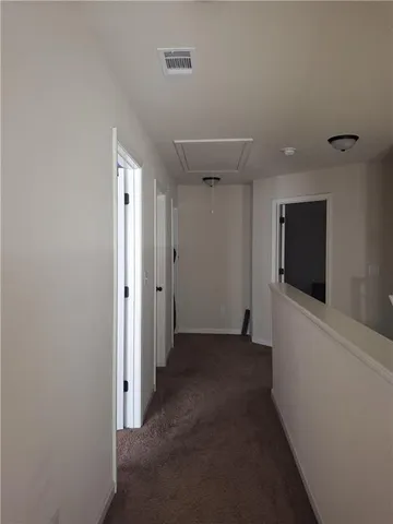 a view of a livingroom with an empty space and a hallway