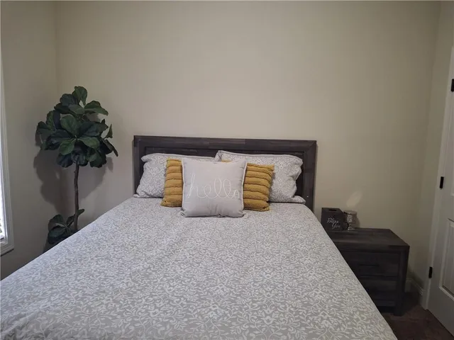 a bedroom with a bed and a potted plant