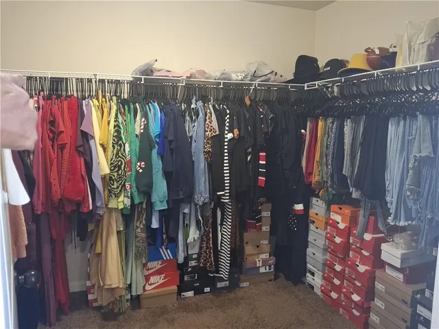a view of walk in closet with clothes and shoes