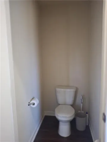 a white toilet sitting next to a white wall