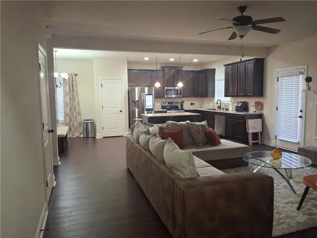 a living room with stainless steel appliances kitchen island granite countertop furniture and a view of kitchen