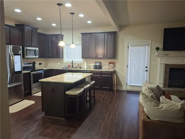 a kitchen with kitchen island granite countertop a sink stainless steel appliances and cabinets