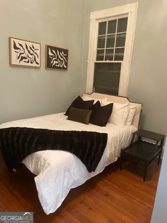 a bedroom with a bed and wooden floor