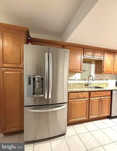 a kitchen with granite countertop a refrigerator and a sink