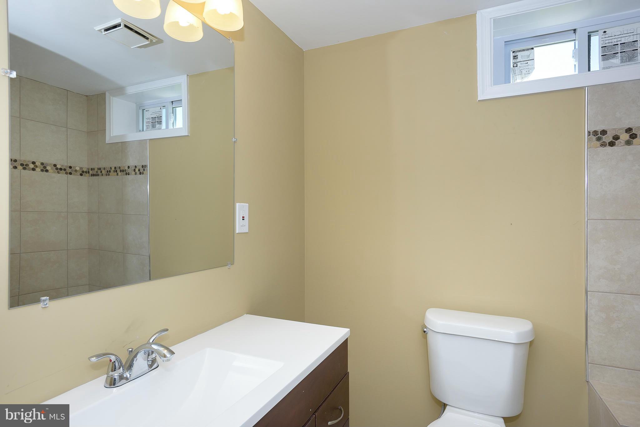 3423 Edcrest Road Baltimore, MD 21244 - Photo 22 of 30 a bathroom with a sink mirror and toilet