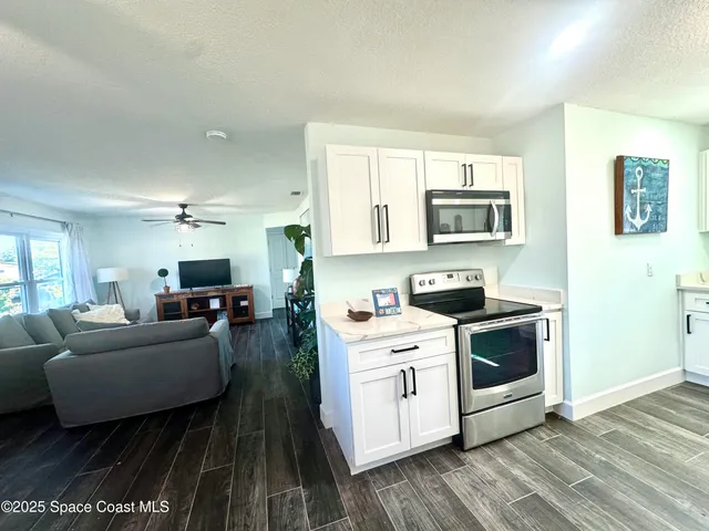 a living room with furniture a stove and a microwave