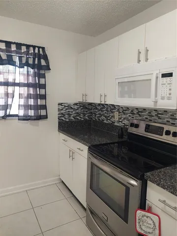 a stove top oven sitting inside of a kitchen