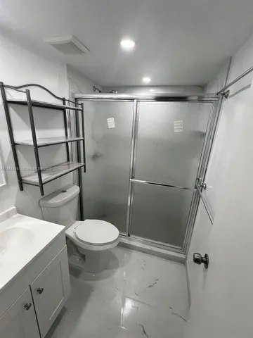 a white toilet sitting next to a shower curtain