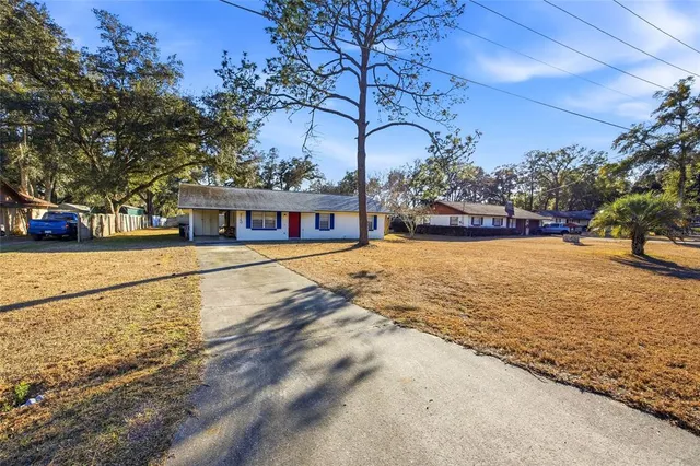 a view of a house with a yard and tree s