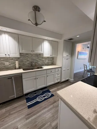 a kitchen with granite countertop a sink a stove and cabinets