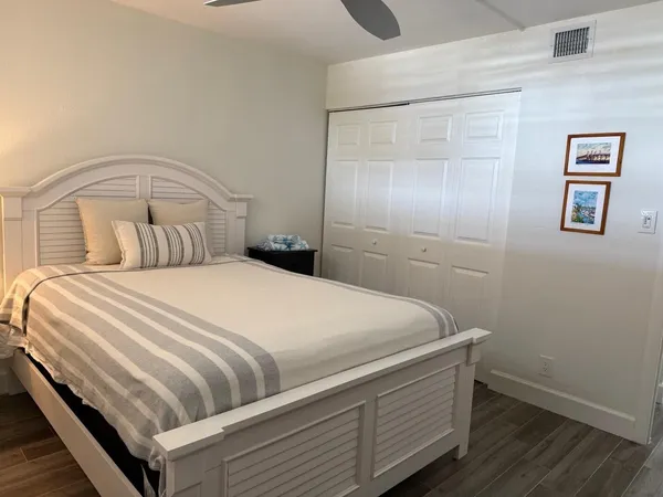 a bedroom with a bed and painting on the wall