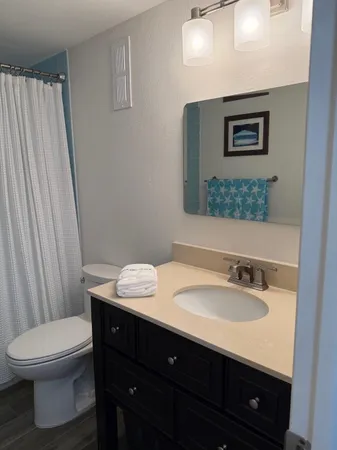 a bathroom with a sink vanity mirror and toilet