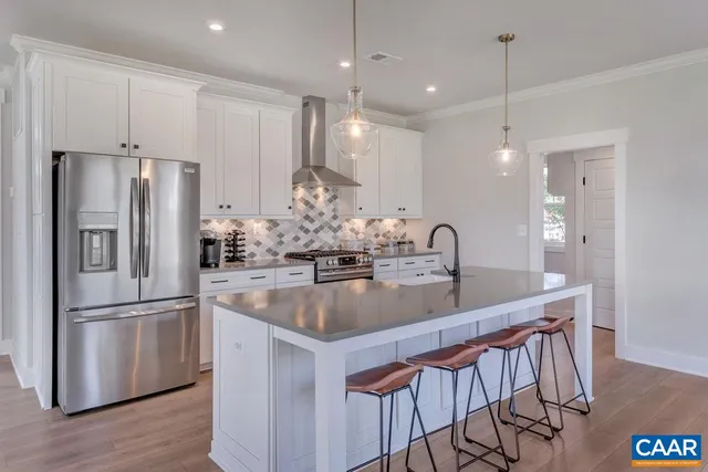 a kitchen with stainless steel appliances granite countertop a kitchen island hardwood floor and a sink