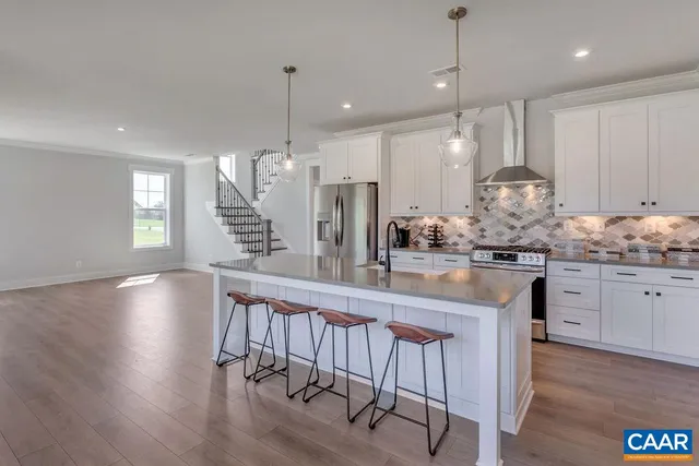 a kitchen with center island white cabinets and wooden floor