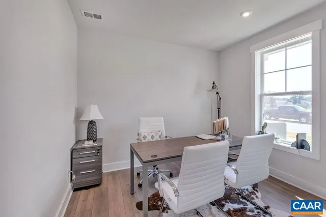 a view of a workspace with furniture and a window