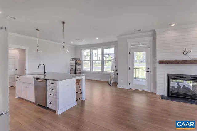 a kitchen with stainless steel appliances granite countertop a stove top oven a sink and a chandelier