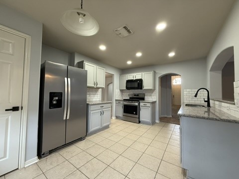 a kitchen with stainless steel appliances granite countertop a refrigerator and a sink