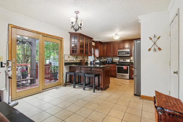 a kitchen with stainless steel appliances kitchen island granite countertop a refrigerator and a stove top oven