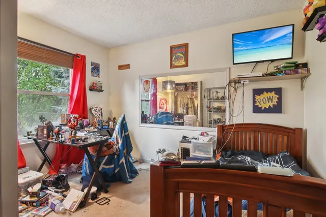 a bedroom with furniture a flat screen tv and a window
