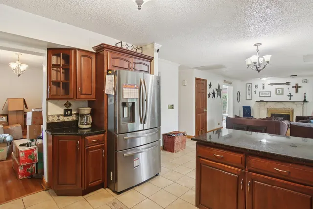 a kitchen with granite countertop a refrigerator and a sink