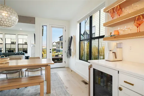a living room with furniture a large window and wooden floor